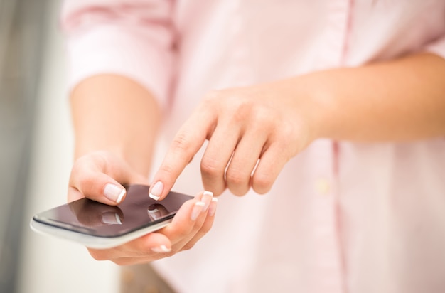 Close-up van jonge vrouw die smartphone gebruiken.