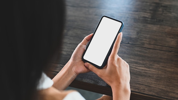 Close-up van jonge vrouw met slimme telefoon met leeg wit scherm