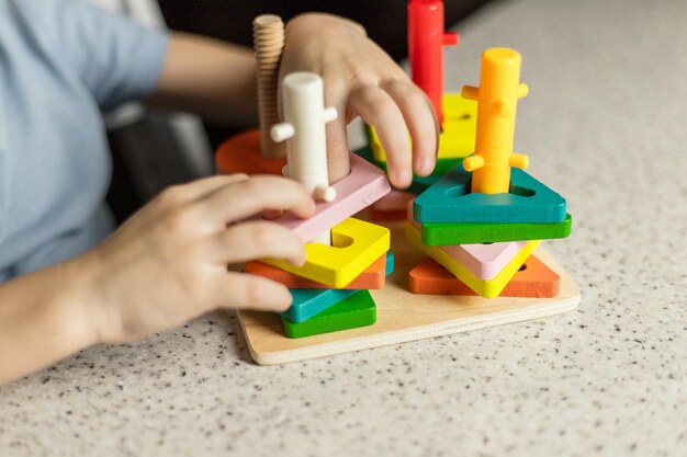 Foto close-up van kinderhanden die spelen met een educatief veelkleurig puzzelstukje