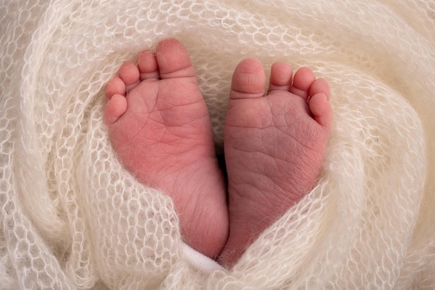 Close-up van kleine schattige blote tenen hakken en voeten van een pasgeboren meisje jongen Baby voet op witte zachte sprei deken Detail van een pasgeboren baby legsMacro horizontale professionele studio foto