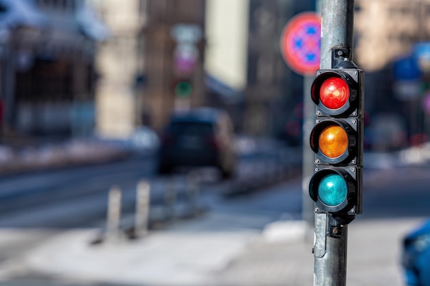 Close-up van kleine verkeersseinpaal met rood licht tegen de achtergrond van het stadsverkeer