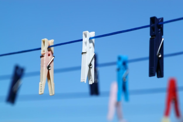 Foto close-up van kleren die aan een touw hangen tegen de blauwe hemel