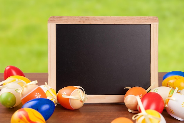 Close-up van kleurrijke paaseieren met een bord op een houten tafel