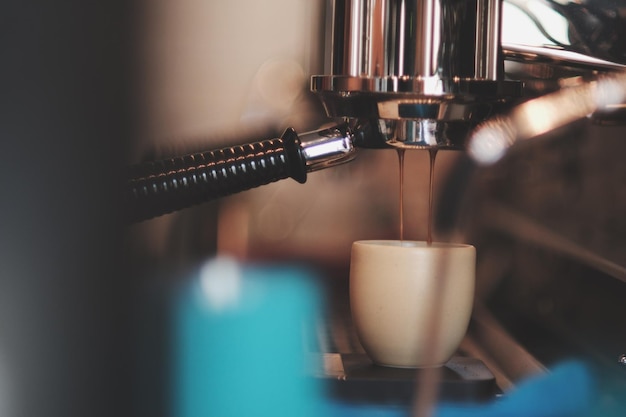 Close-up van koffie die in een kopje van machines in een café wordt gegoten