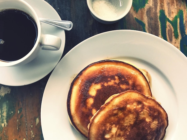 Close-up van koffie en pannenkoeken op tafel