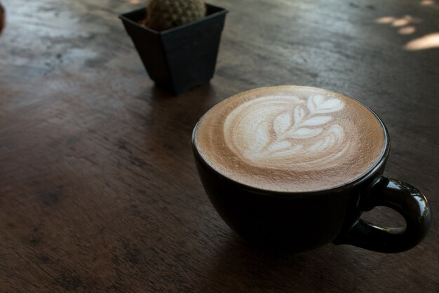 Close-up van kopje hete latte kunst koffie op houten tafel