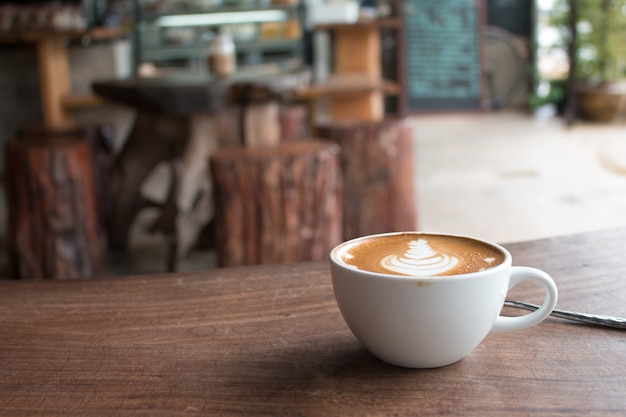 Close-up van kopje hete latte kunst koffie op houten tafel