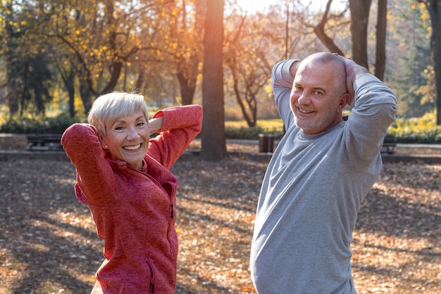 Foto close-up van lachend kaukasisch senior koppel dat traint in een park op een zonnige herfstdag