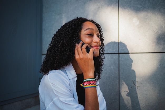 Close up van lachende Afrikaanse vrouw praten op de slimme telefoon met vrienden