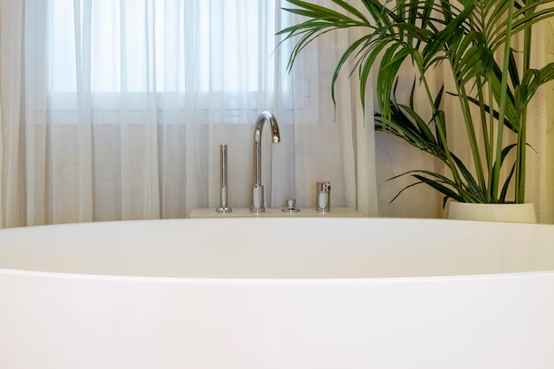 Close-up van luxe moderne badkamer interieur met witte badkuip en kamerplant