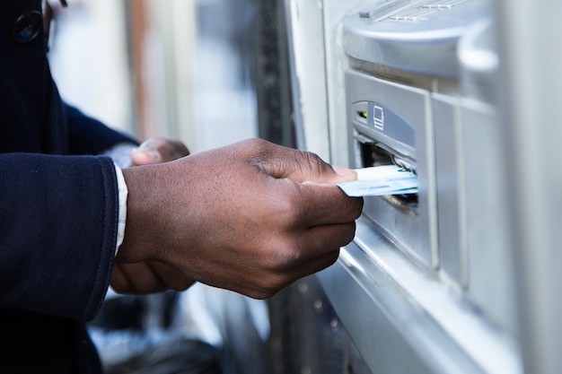 Close up van man die contant geld van ATM met creditcard neemt.