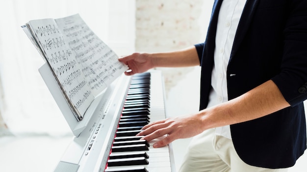 Foto close-up van man hand die de piano speelt