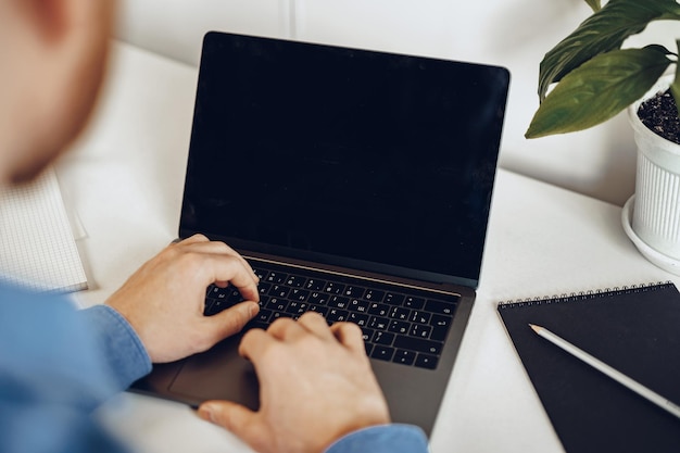 Close up van mannelijke handen typen op laptop met zwart scherm