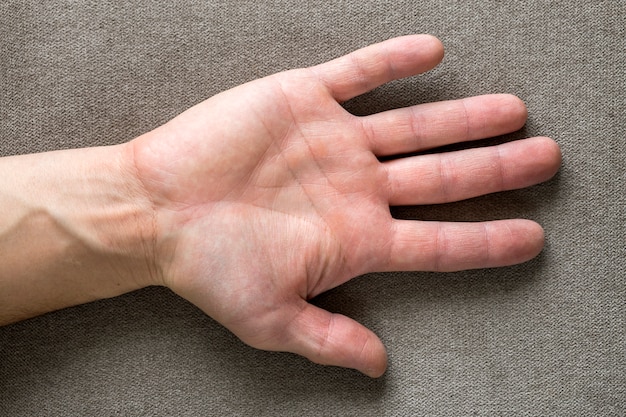 Close-up van mannelijke mannelijke hand met ruwe huid en korte vingernagels die op vlakke exemplaar ruimte, hoogste mening rusten. Handarbeid en handen zorg concept.