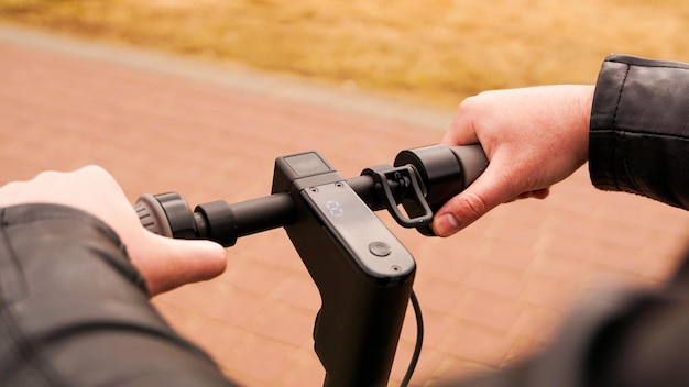 Close-up van mannenhand op snelheidsknop op elektrische scooter te drukken. foto buiten in het park