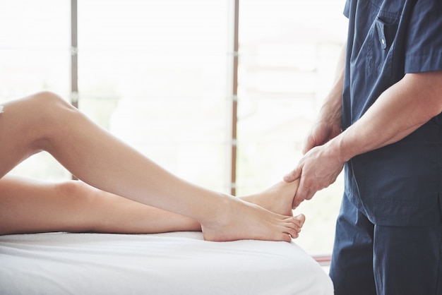 Close-up van massagetherapeut die mooi vrouwelijk been masseren