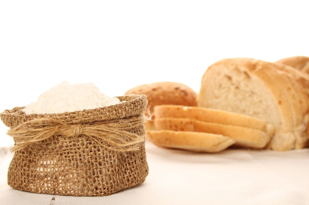 Close-up van meel in een zak en verschillende soorten brood Isoleren