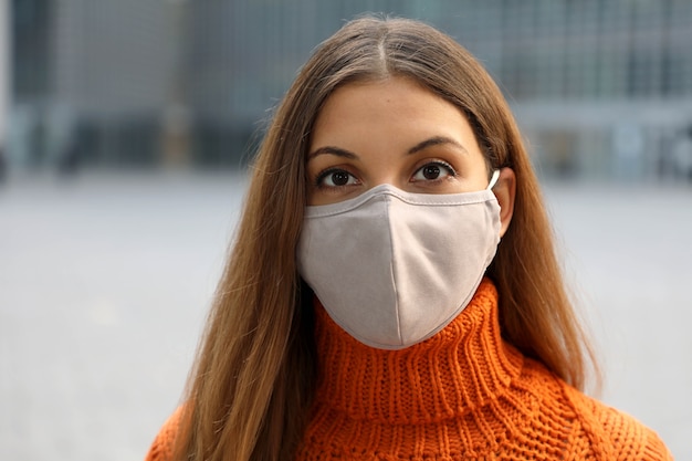 Close up van meisje dragen gezichtsmasker poseren in de straat camera kijken