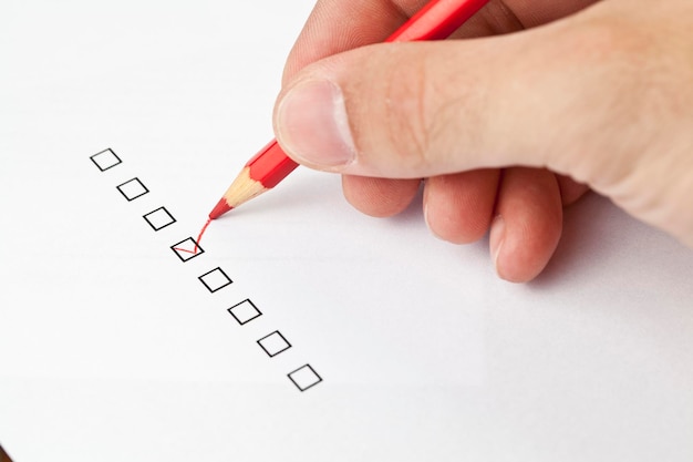 Close-up van menselijk handschrift op papier met checklist