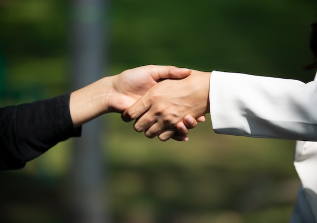 Foto close-up van mensen die elkaar de hand schudden