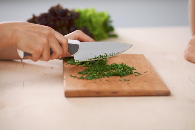 Close-up van mensenhanden die groentensalade in keuken koken Gezonde maaltijd en vegetarisch concept