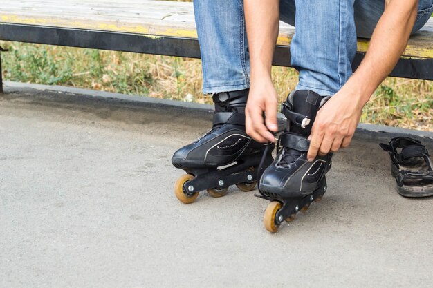 Close-up van mensenkerel die op rolschaatsen zetten openlucht