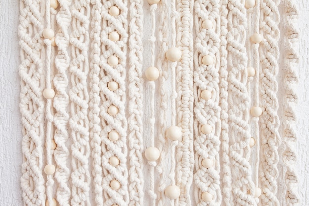 Close-up van met de hand gemaakt macrame structuurpatroon. eco-vriendelijk modern breien. natuurlijk decoratieconcept in het interieur.