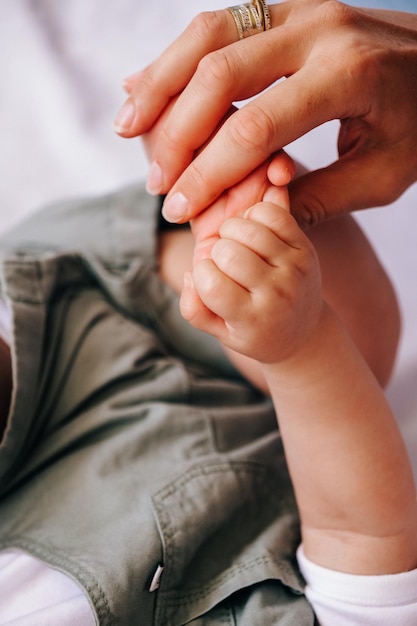 Close-up van moeder die babyhand op wit blad houdt Gelukkig moederschap