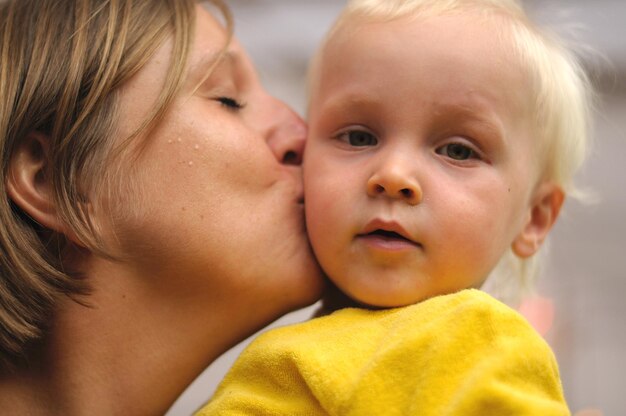 Close-up van moeder die zoon zoent