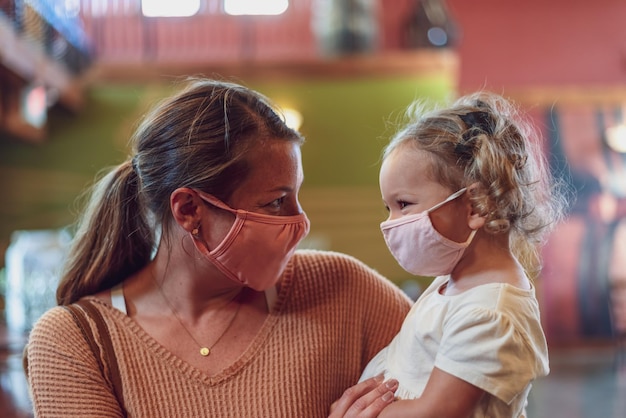 Close-up van moeder en dochter die maskers dragen en buiten schuiven