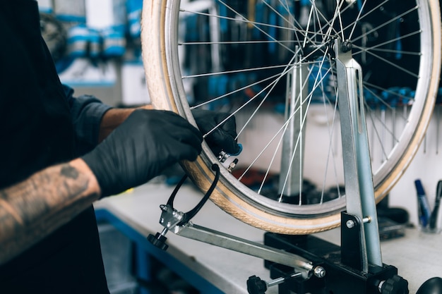 Close up van monteur repareren van fietsen in een werkplaats.