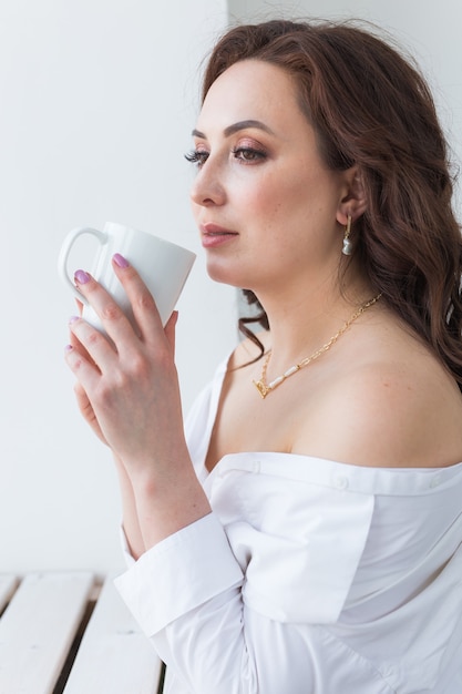 close-up van mooie feman handen met grote witte kopje cappuccino koffie.