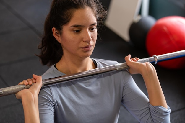 Foto close up van mooie sportvrouw doen oefeningen binnenshuis in de sportschool, halter opheffen