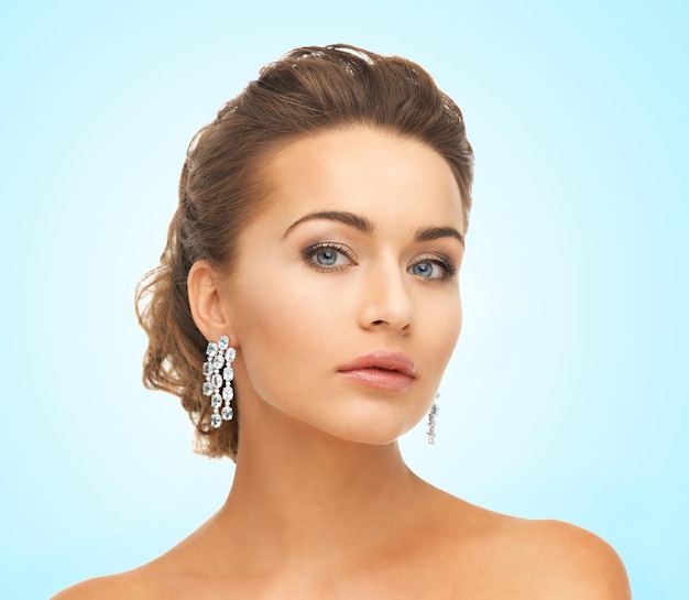 close-up van mooie vrouw die glanzende diamanten oorbellen draagt
