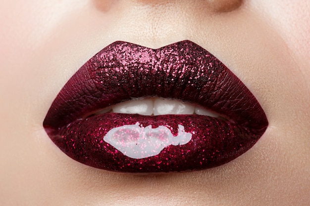 Close-up van mooie vrouw lippen met glanzende donkerrode lippenstift