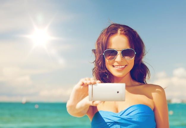 close-up van mooie vrouw op het strand met telefoon