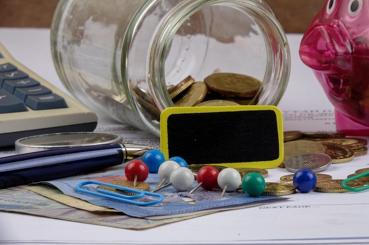 Foto close-up van munten met kantoorbenodigdheden op tafel
