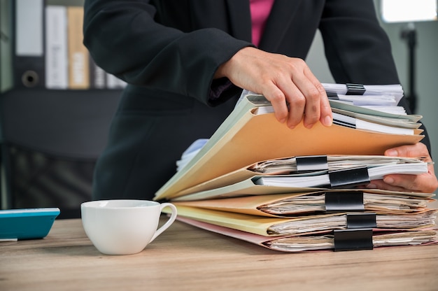 Close-up van Office-medewerker die werkt met documenten aan de balie in een bedrijfskantoor