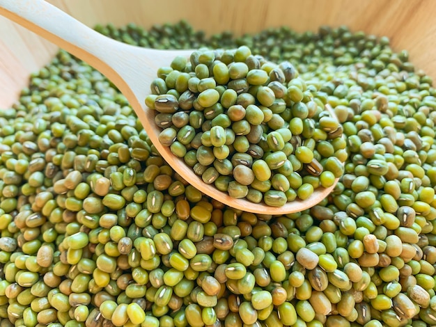 Foto close-up van om het even welke mungbean of slabonen op een houten lepel in een houten kom