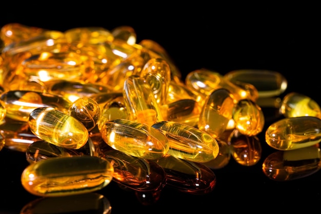 Close-up van Omega 3-gelcapsule op een reflecterende zwarte achtergrond