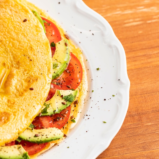 Foto close-up van omelet met tomaten en avocado op plaat