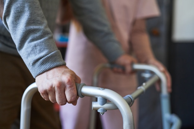 Foto close up van onherkenbare senior man met rollator in verpleeghuis mobiliteit en hulp achtergrond...