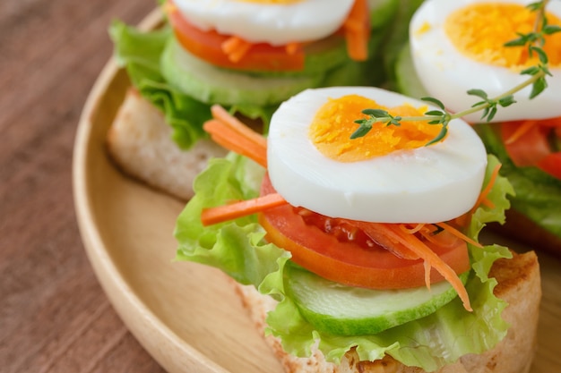 Close-up van open geconfronteerd sandwich met toast sla tomaat wortel komkommer en gekookt ei.