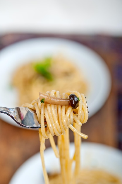 Close-up van paddenstoel en spaghetti op vork