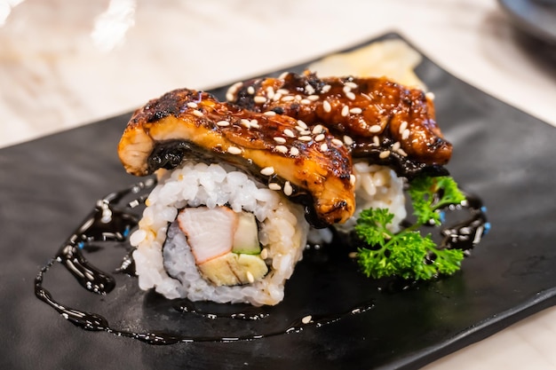 Close-up van palingsushi op een zwarte traditionele Japanse betegelde plate