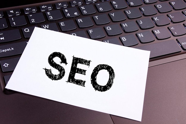 Close-up van papier met seo tekst op laptop