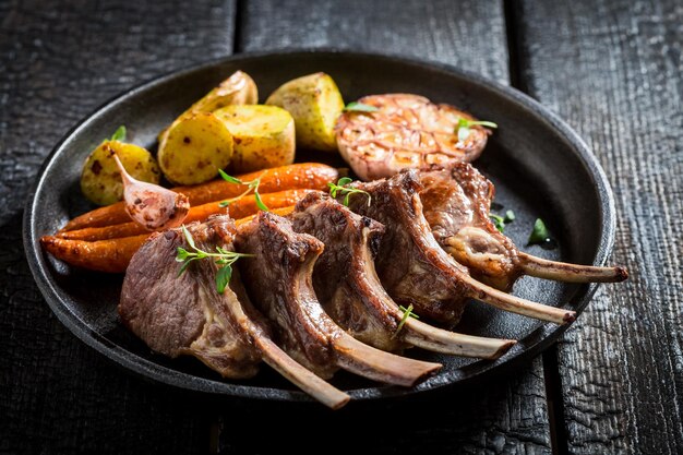 Close-up van pittige gegrilde lamsribbetjes op donkere achtergrond