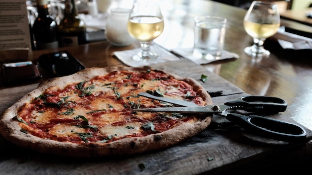 Close-up van pizza en schaar op tafel