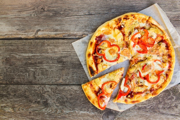 Close-up van pizza met kip, tomaten, kaas, champignons en specerijen