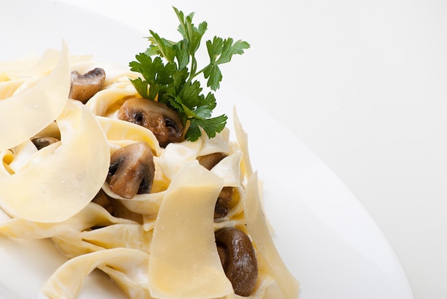 Foto close-up van plaat van tagliatelle met romige saus van champignonkaas en parmezaanse kaas